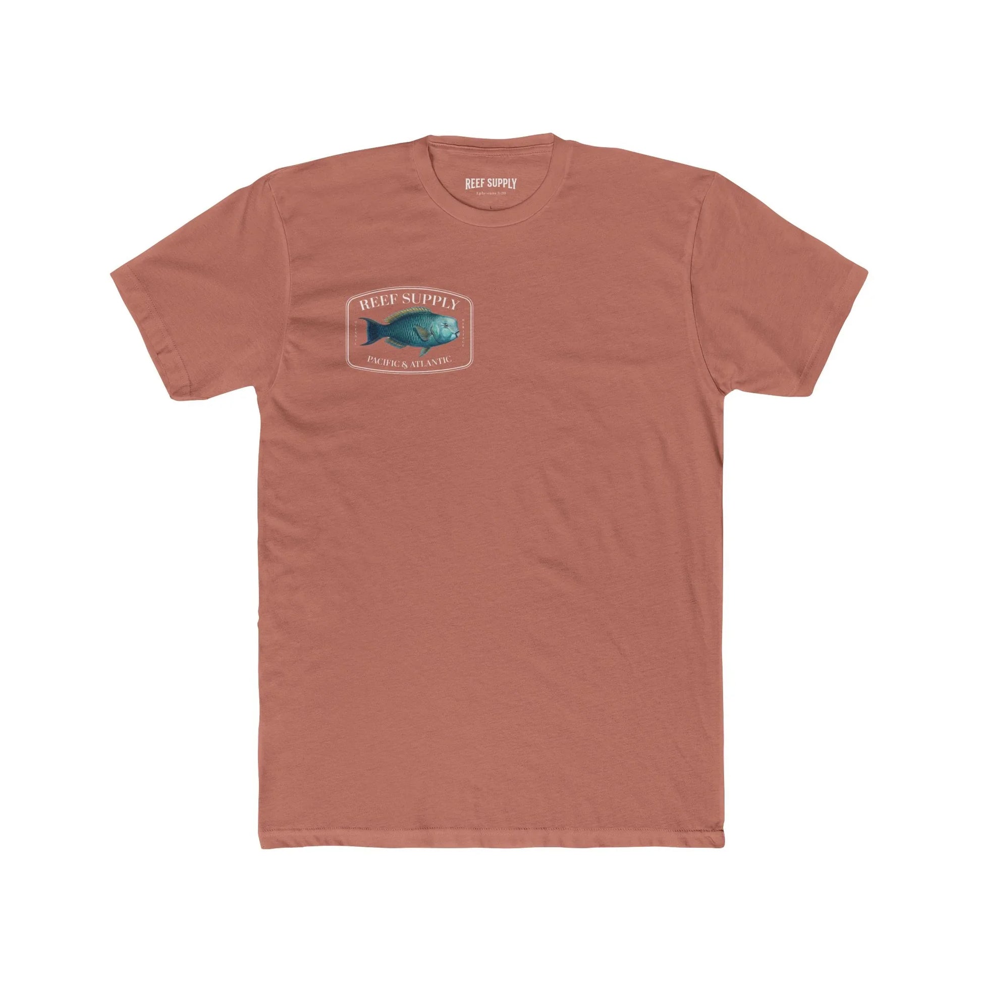 A close-up view of the front of a coral colored premium cotton t-shirt. The centerpiece is a detailed, vibrant illustration of a blue Parrotfish, reflecting its natural colors. The Reef Supply brand logo is arched over the top of the fish, with 'Pacific & Atlantic' text printed in a clean font beneath it, highlighting our coastal inspiration