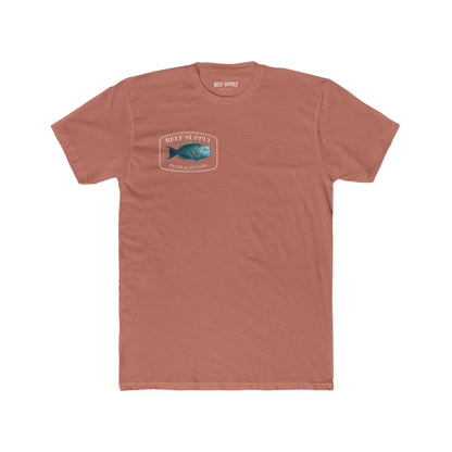 A close-up view of the front of a coral colored premium cotton t-shirt. The centerpiece is a detailed, vibrant illustration of a blue Parrotfish, reflecting its natural colors. The Reef Supply brand logo is arched over the top of the fish, with 'Pacific & Atlantic' text printed in a clean font beneath it, highlighting our coastal inspiration