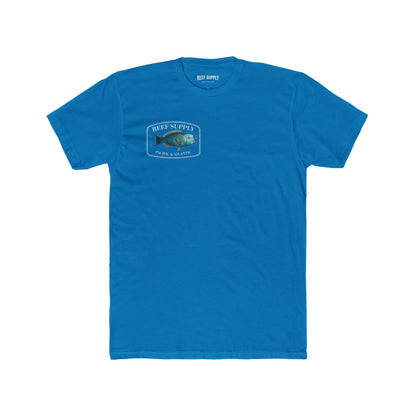 A close-up view of the front of a blue premium cotton t-shirt. The centerpiece is a detailed, vibrant illustration of a blue Parrotfish, reflecting its natural colors. The Reef Supply brand logo is arched over the top of the fish, with 'Pacific & Atlantic' text printed in a clean font beneath it, highlighting our coastal inspiration