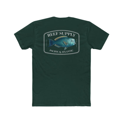 A close-up view of the back of a forest green premium cotton t-shirt. The centerpiece is a detailed, vibrant illustration of a blue Parrotfish, reflecting its natural colors. The Reef Supply brand logo is arched over the top of the fish, with 'Pacific & Atlantic' text printed in a clean font beneath it, highlighting our coastal inspiration