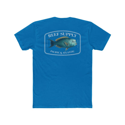 A close-up view of the back of a blue premium cotton t-shirt. The centerpiece is a detailed, vibrant illustration of a blue Parrotfish, reflecting its natural colors. The Reef Supply brand logo is arched over the top of the fish, with 'Pacific & Atlantic' text printed in a clean font beneath it, highlighting our coastal inspiration