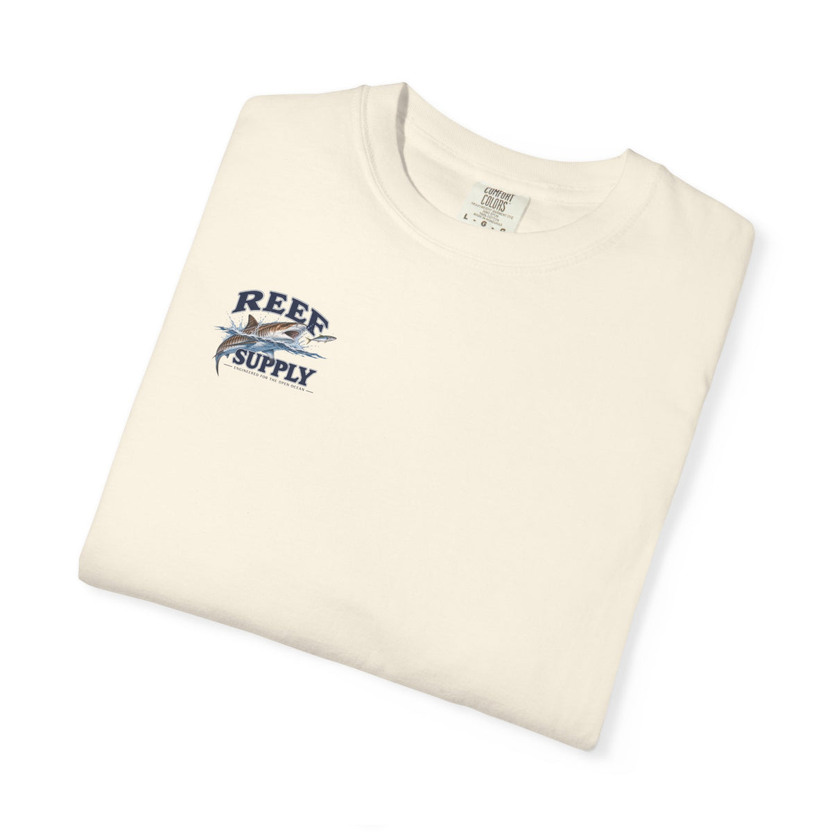 Folded cream Tiger Tee featuring a Reef Supply graphic logo with a fish design.