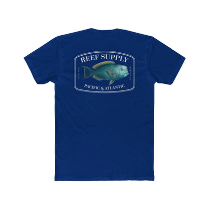 A close-up view of the back of a dark blue premium cotton t-shirt. The centerpiece is a detailed, vibrant illustration of a blue Parrotfish, reflecting its natural colors. The Reef Supply brand logo is arched over the top of the fish, with 'Pacific & Atlantic' text printed in a clean font beneath it, highlighting our coastal inspiration