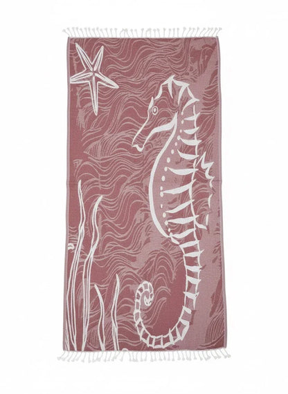 Beach towel with seahorse and starfish design on a pink background