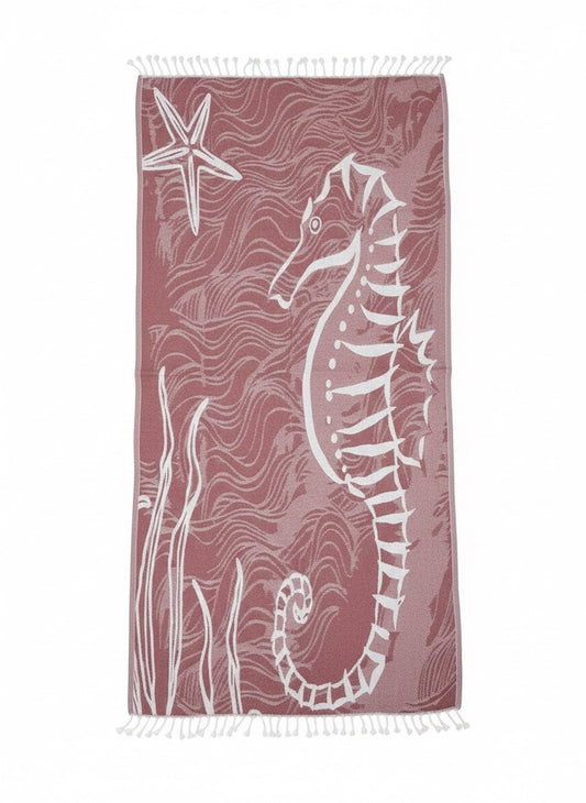 Beach towel with seahorse and starfish design on a pink background